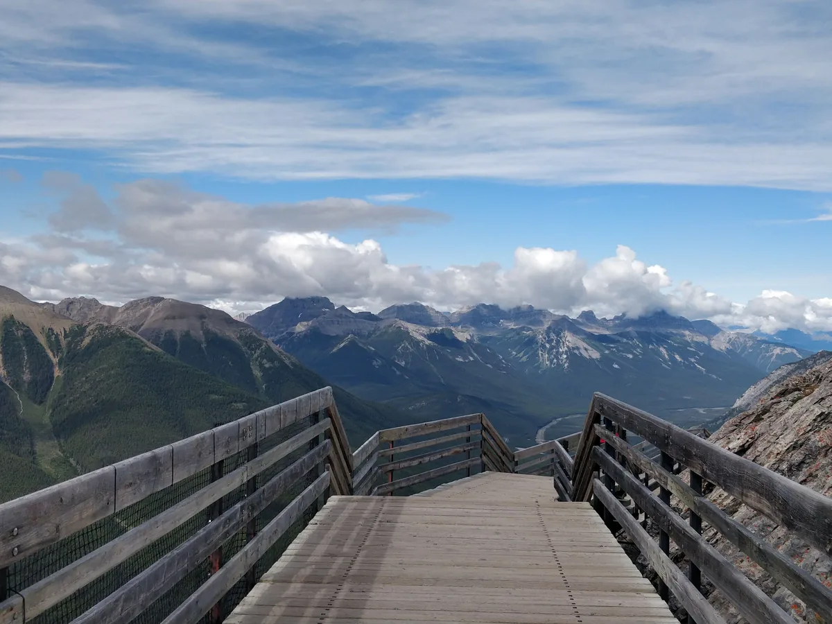 A wooden viewing boardwalk leading toward a mountain view